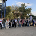 Elite d'Or students and administration group photo at the International Book Fair with the Great Mosque of Algiers in the background