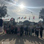 Elite d'Or students and administration group photo at the International Book Fair with the Great Mosque of Algiers in the background