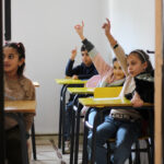 Elite-dOr-students-raising-their-hands-to-participate-during-a-classroom-lesson-session