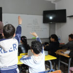 Elite-dOr-students-raising-their-hands-to-participate-during-a-classroom-lesson-session