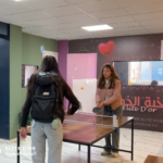 Elite d'Or two students playing ping pong inside the academy recreational area