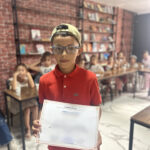 Elite d'Or young student smiling proudly holding his certificate from the language program Dellys Algeria